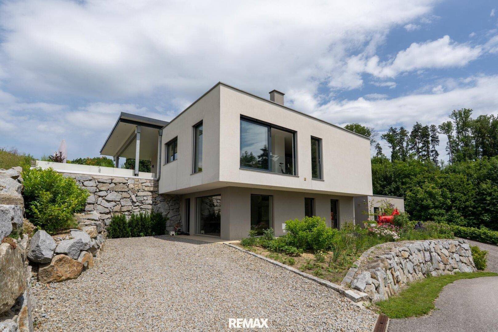Modernes Einfamilienhaus mit großen Fenstern und ansprechender Außenarchitektur.