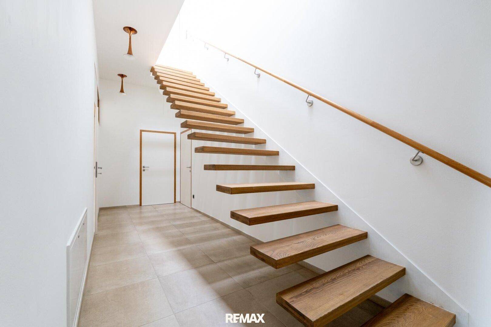 Heller Flur mit moderner Holztreppe und minimalistischem Design.