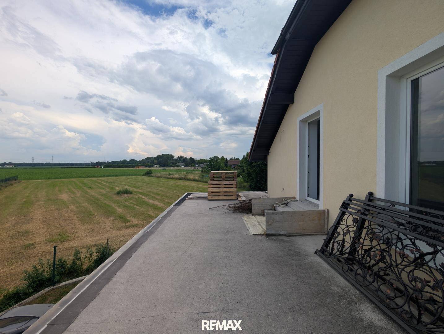 Große Betonterrasse im Rohbau mit weitem Blick über die Felder.