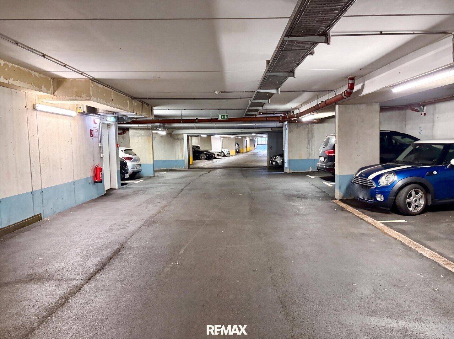 Tiefgarage mit mehreren geparkten Autos und ausreichend Platz für weitere Fahrzeuge.