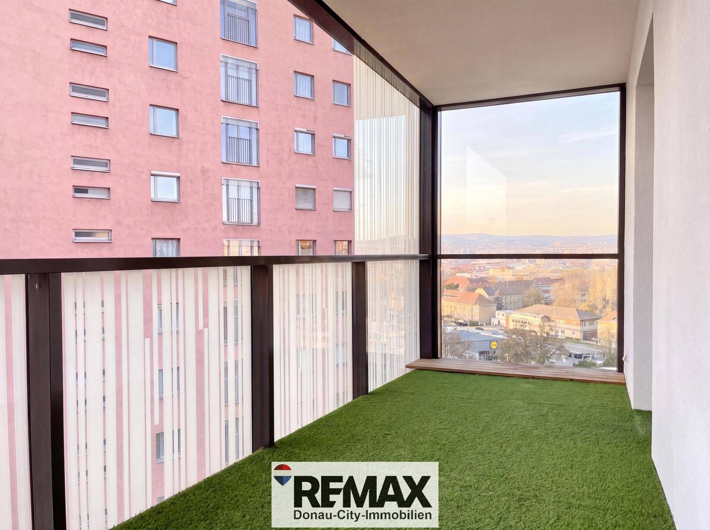 Balkon mit Kunstrasen und Glasbrüstung, bietet einen weiten Blick über die Umgebung.
