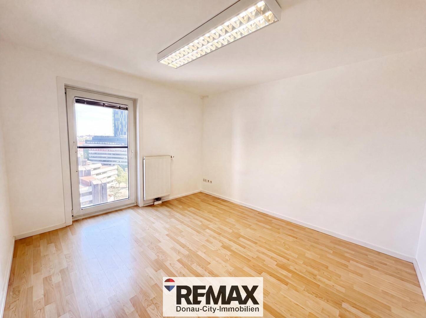Helles, unmöbliertes Zimmer mit Holzboden und großem Fenster, vielseitig nutzbar.