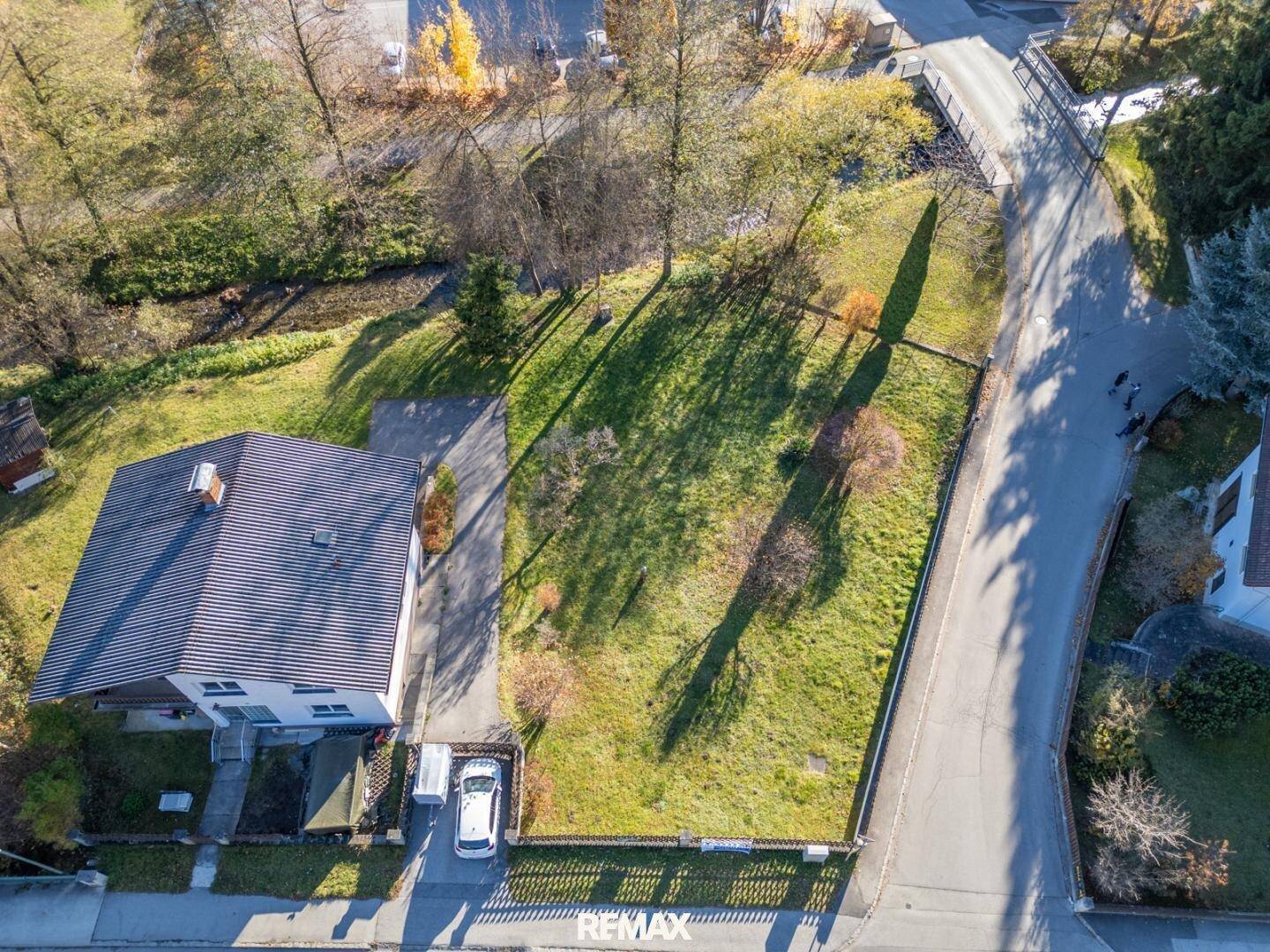 Senkrechte Luftaufnahme eines Hauses mit Rasenfläche, Einfahrt und angrenzenden Straßen in ländlicher Umgebung.