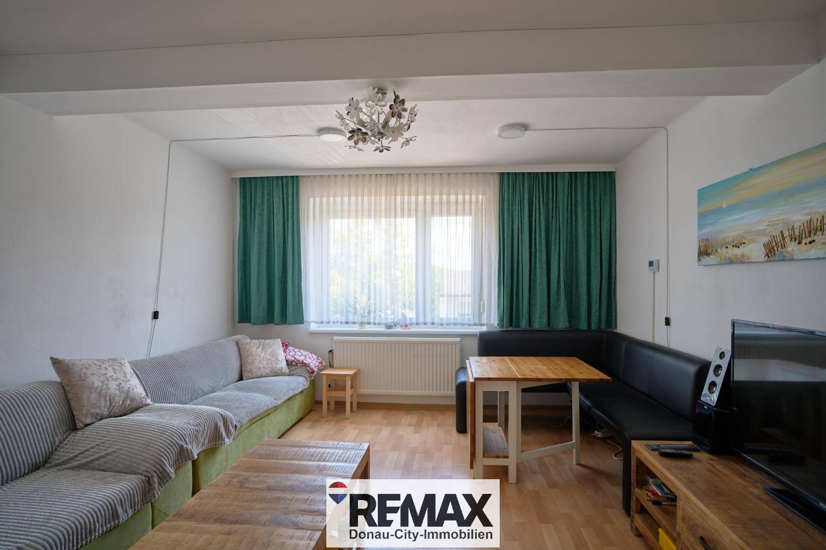 Gemütliches Wohnzimmer mit Ecksofa, Esstisch und Blick ins Grüne.