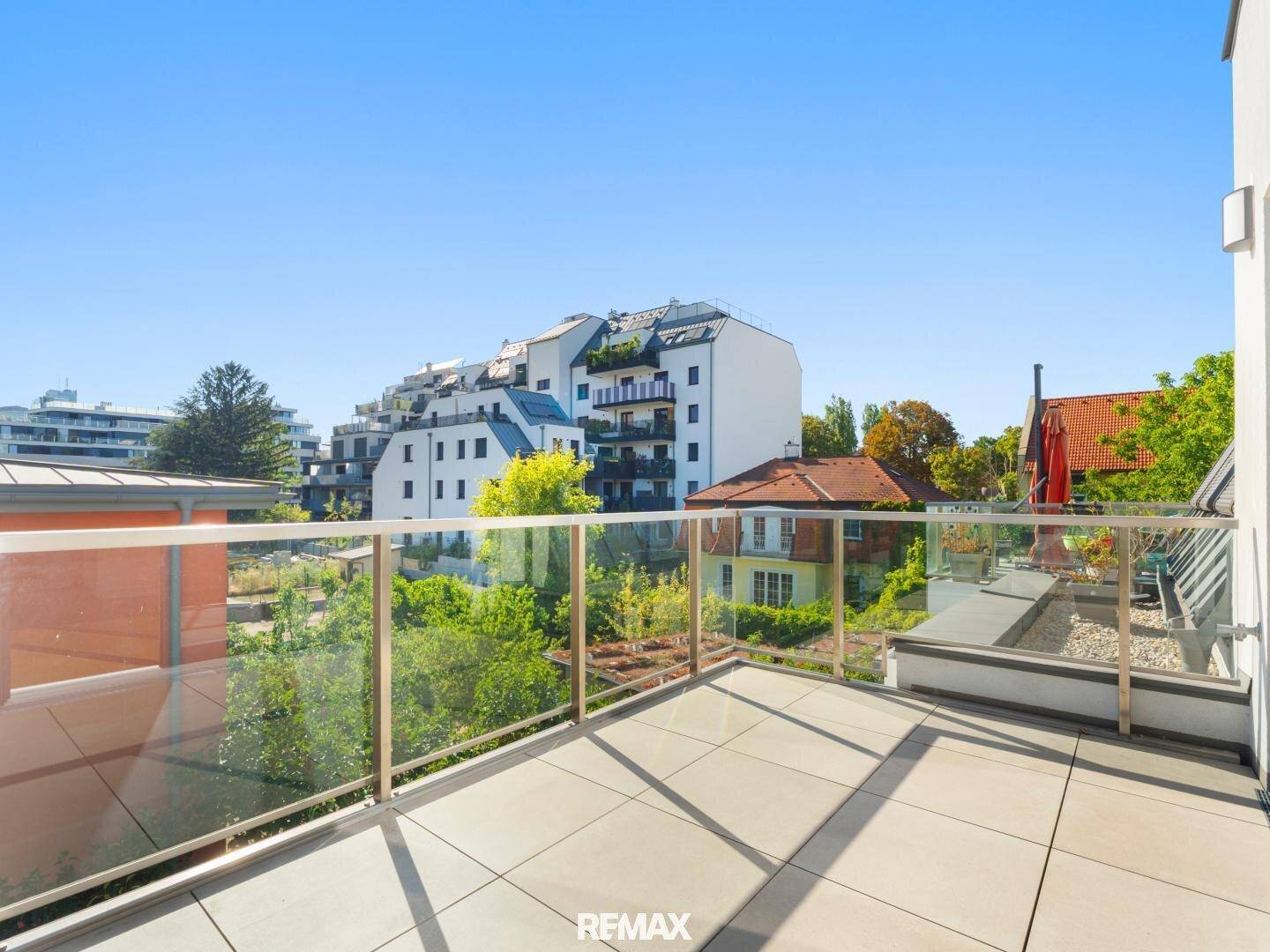 Weitläufige Terrasse mit Blick auf die umliegenden Gebäude und viel Grün.