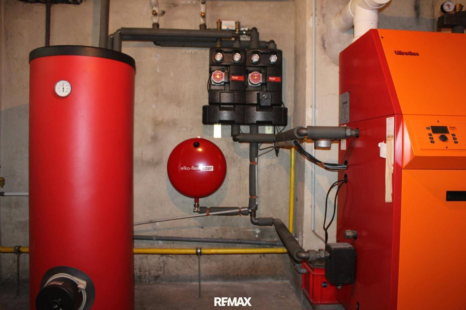 Heizungsraum mit Warmwasserspeicher und Heizkessel, gut gewartet und funktionsfähig.