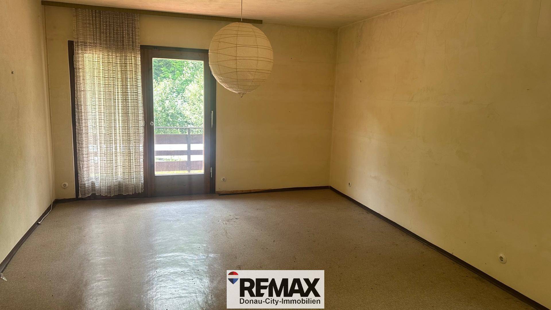 Geräumiges Zimmer mit Zugang zu einem Balkon und viel Tageslicht.