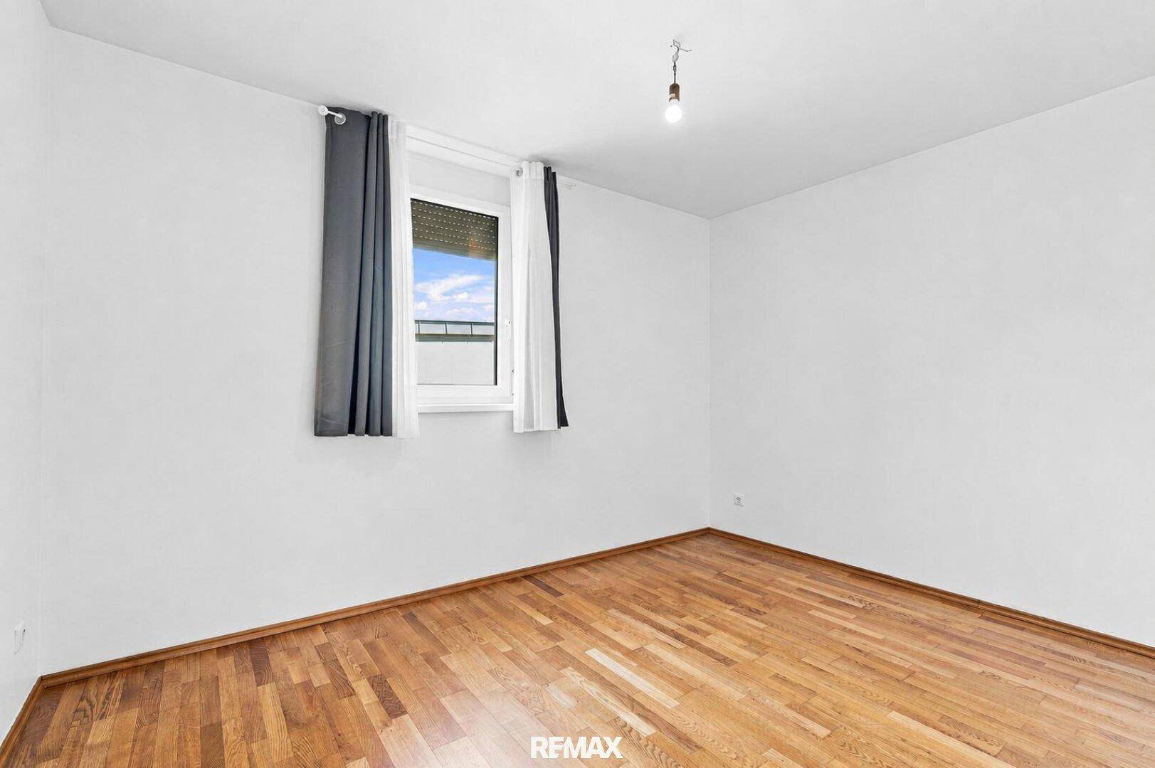 Helles Zimmer mit Holzboden und Fenster mit Rollladen, vielseitig nutzbar.