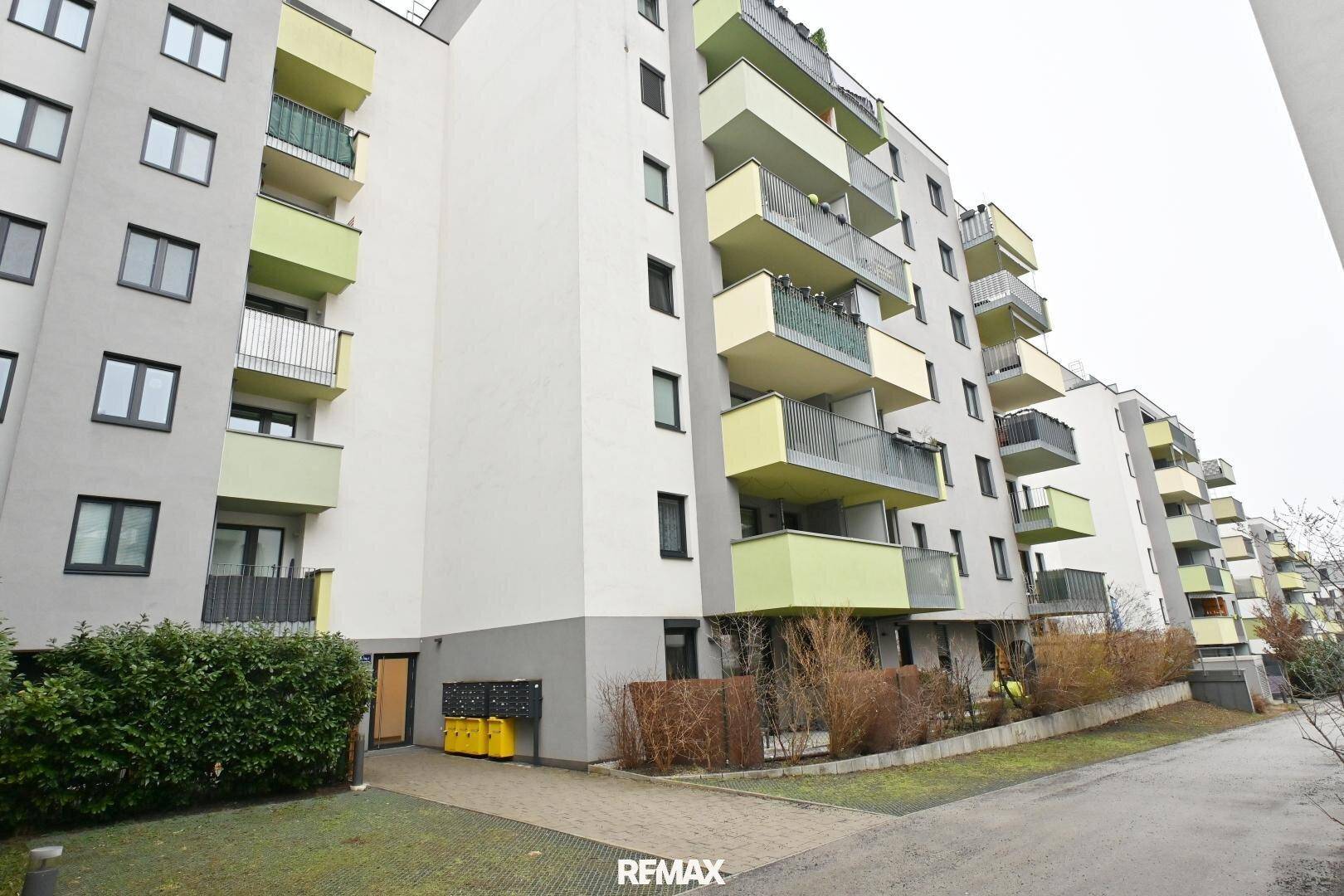Moderne Wohnanlage mit zahlreichen Balkonen und farbigen Akzenten an der Fassade.