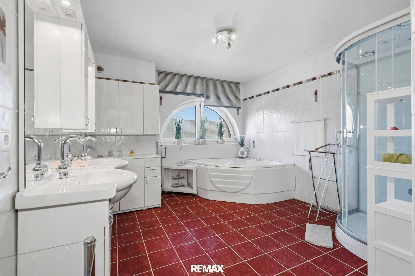 Geräumiges Badezimmer mit Eckbadewanne, Duschkabine und Doppelwaschbecken.