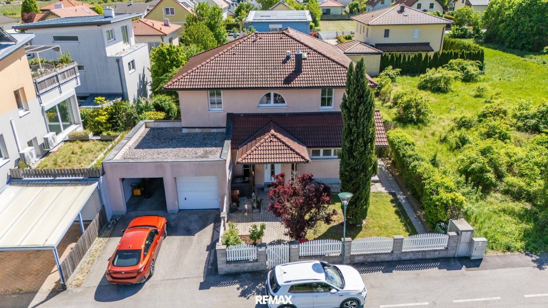 Luftaufnahme des Einfamilienhauses mit Vorgarten, Garage und Zufahrt.