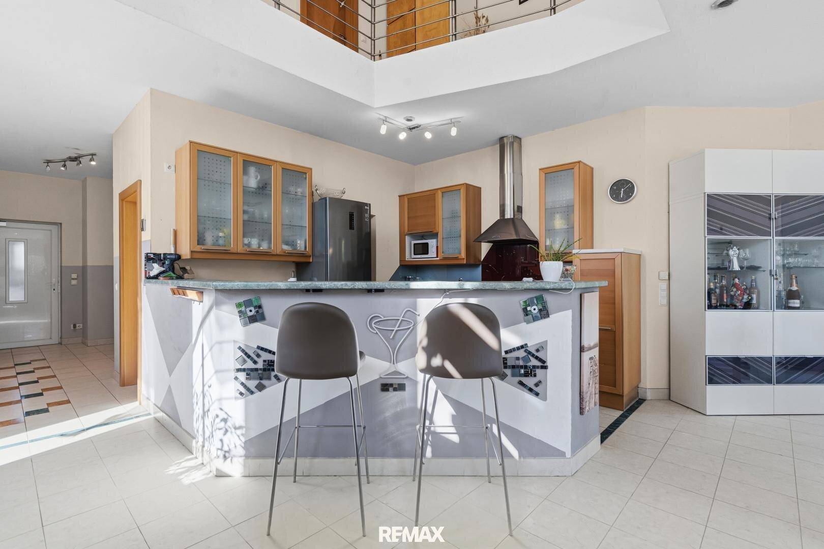 Offener Küchenbereich mit Frühstücksbar und Hockern, ideal für geselliges Beisammensein.