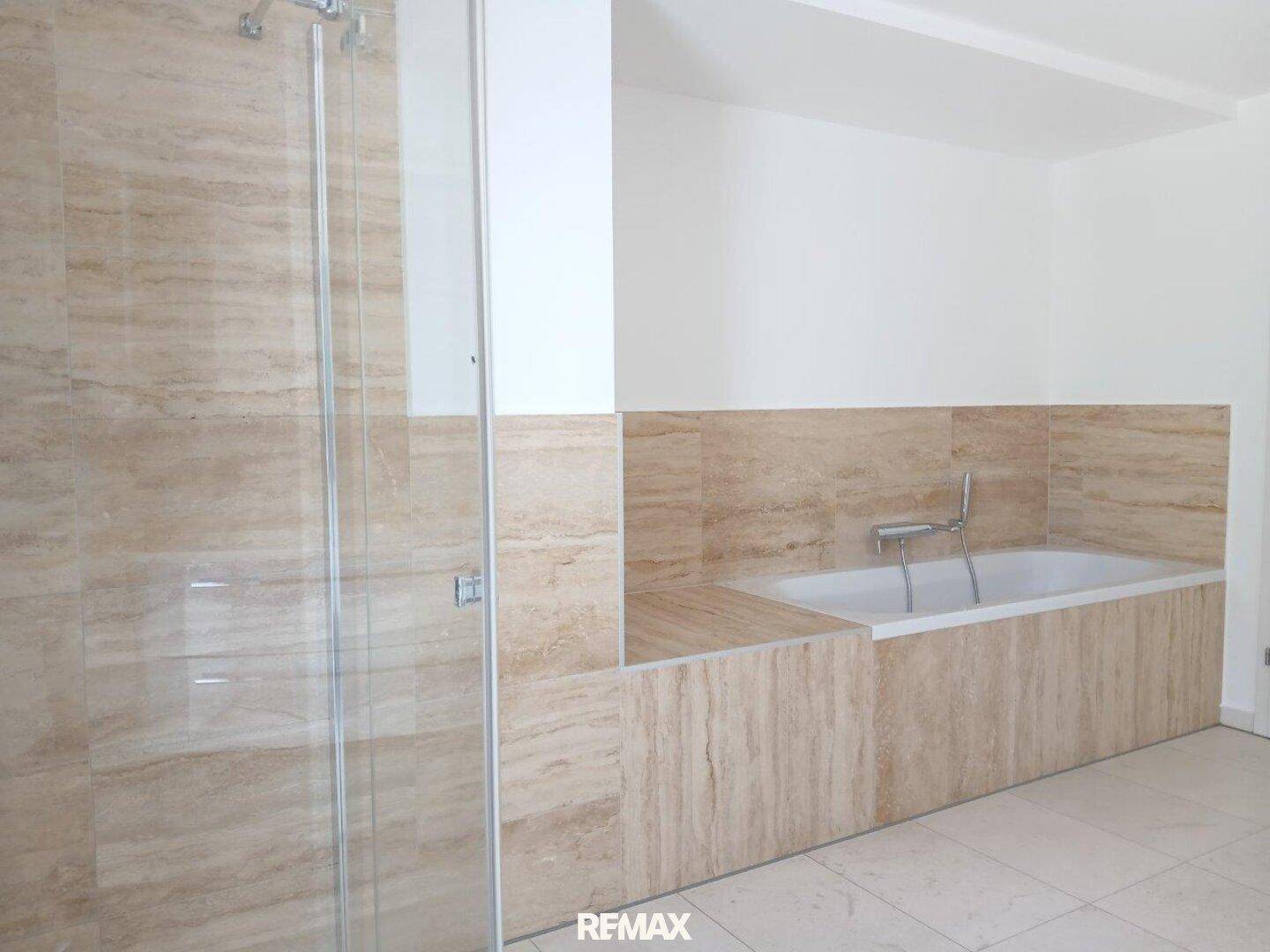 Geräumiges Badezimmer mit eingebauter Badewanne und begehbarer Dusche.