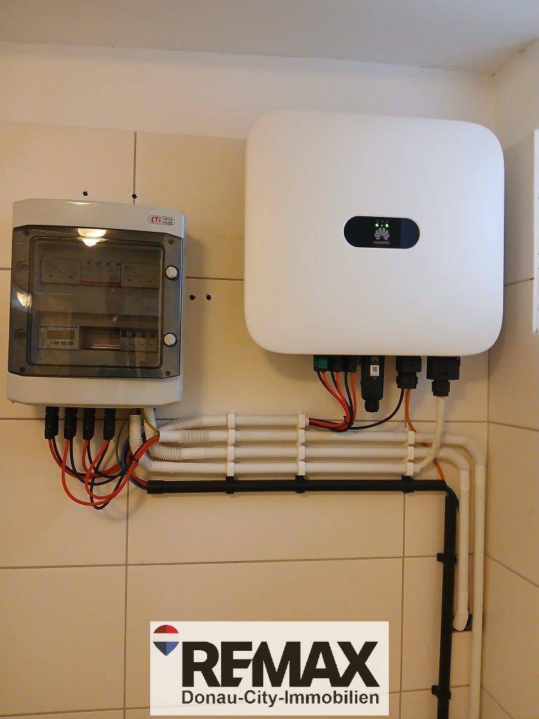 Elektrische Installationen und Wechselrichter für die Photovoltaikanlage in einem Technikraum, sauber an der Wand montiert.