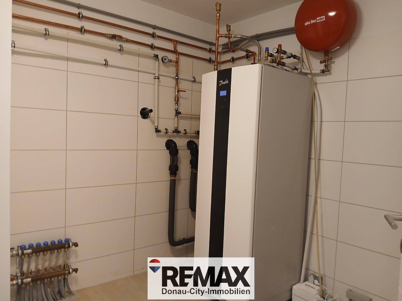 Technikraum mit moderner Heizungsanlage und ordentlich verlegten Rohren, die eine effiziente Wärmeversorgung gewährleisten.