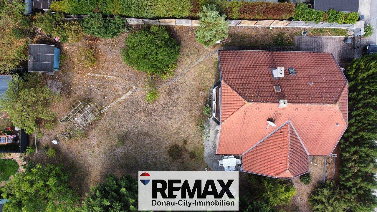 Luftaufnahme des gesamten Grundstücks mit Haus, großem Garten und umliegender Landschaft.