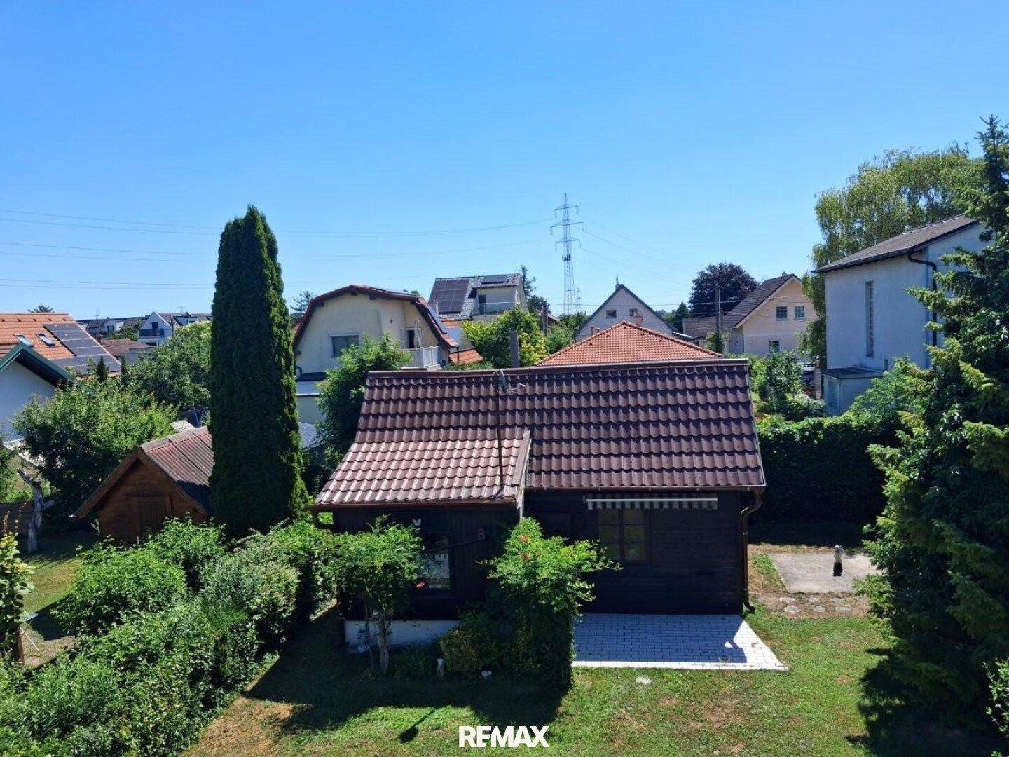 Luftaufnahme des Hauses mit großem Garten, umgeben von Bäumen und anderen Wohnhäusern in der Nachbarschaft.