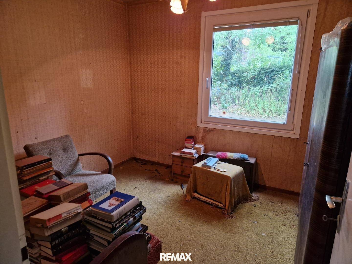Schlafzimmer im Vintage-Stil mit Teppichboden, Fenster und Blick ins Grüne.