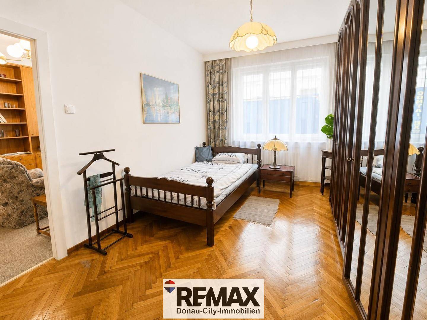 Gemütliches Schlafzimmer mit klassischem Parkettboden, Einzelbett und großem Kleiderschrank.