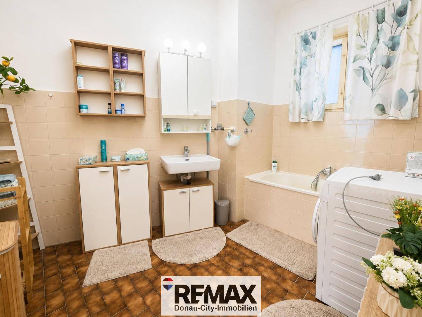 Helles Badezimmer mit Badewanne, Waschbecken, Spiegelschrank und Waschmaschine.