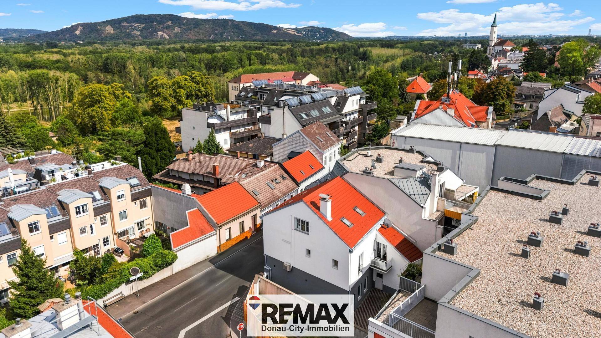 Panoramablick aus der Vogelperspektive auf das Wohngebiet mit grüner Umgebung und Bergen.