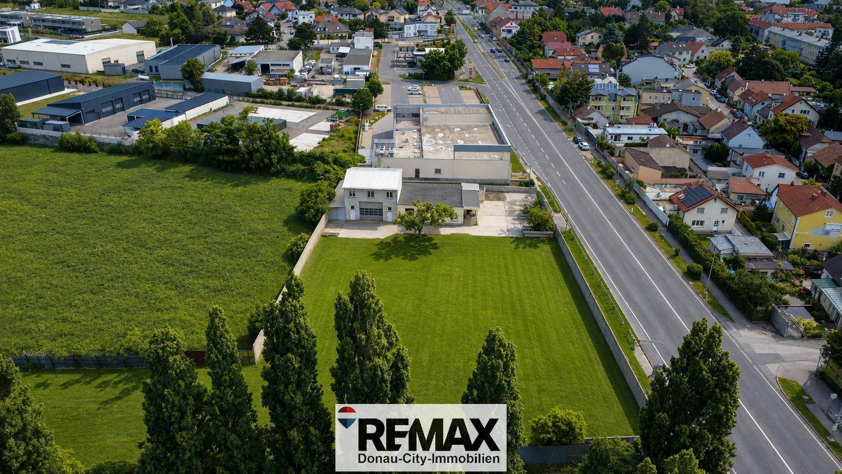 Weitläufige Luftaufnahme eines großen Grundstücks mit angrenzender Straße und Wohnbebauung im Hintergrund.
