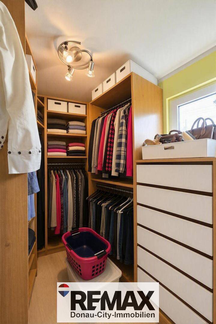 Praktischer begehbarer Kleiderschrank mit Regalen, Kleiderstangen und Kommode für viel Stauraum.