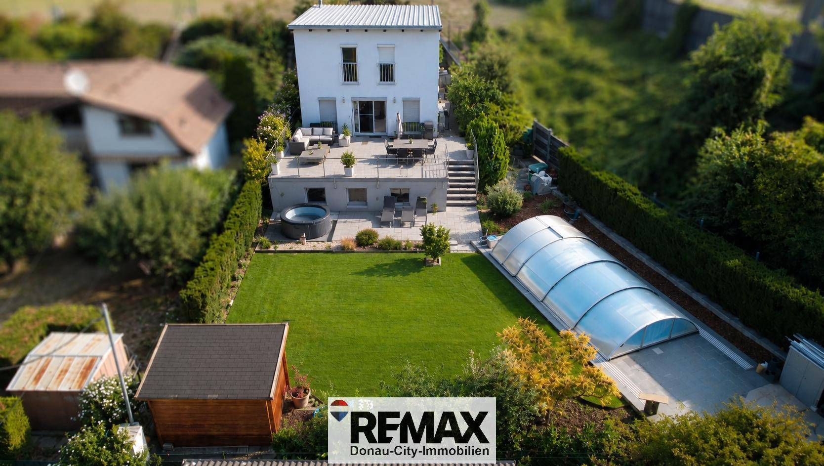 Luftaufnahme eines Hauses mit mehreren Terrassen, großem Garten, Pool und Whirlpool.