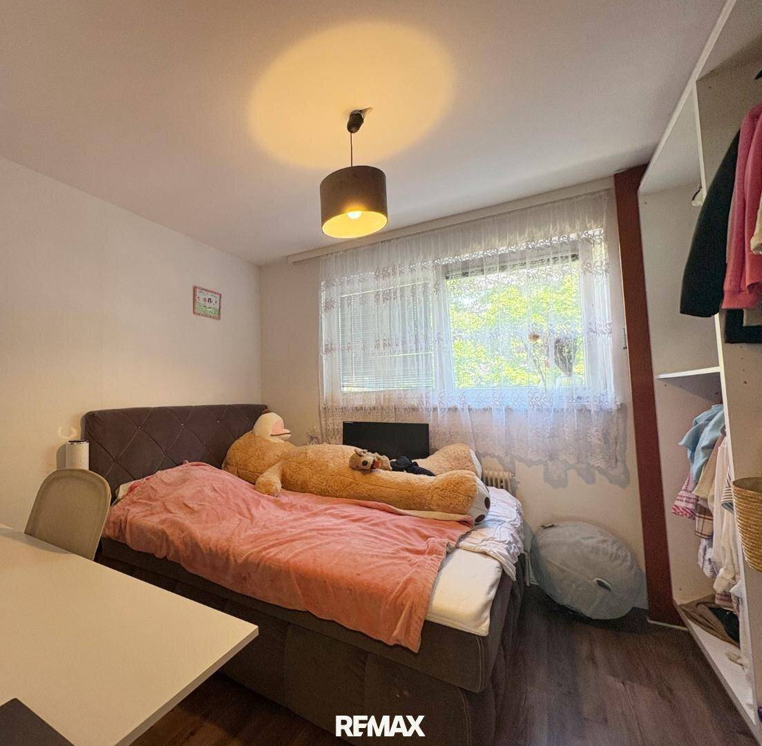 Gemütliches Schlafzimmer mit Doppelbett, Fenster und offenem Kleiderschrank, hell und einladend.