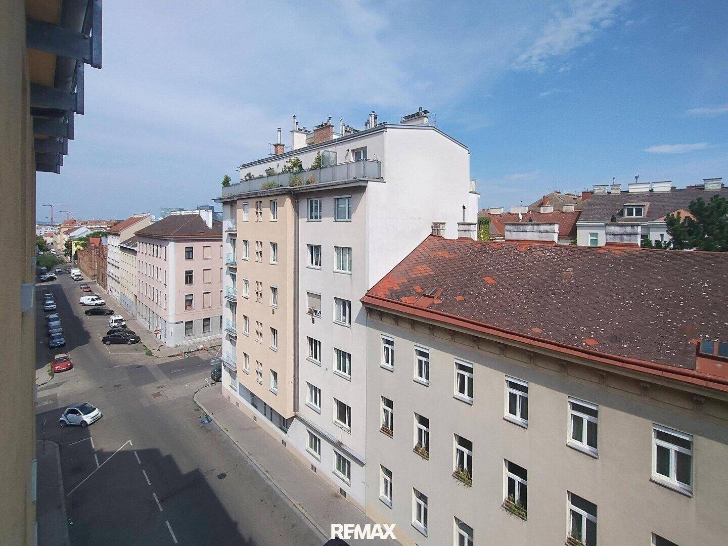 Panoramablick auf städtische Gebäude und Dächer unter blauem Himmel.