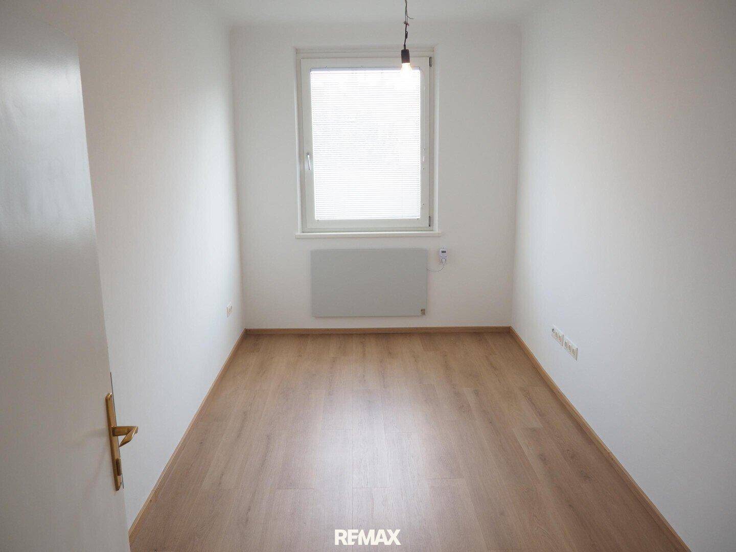 Kleines, helles Zimmer mit Laminatboden und Fenster, geeignet als Kinder- oder Arbeitszimmer.