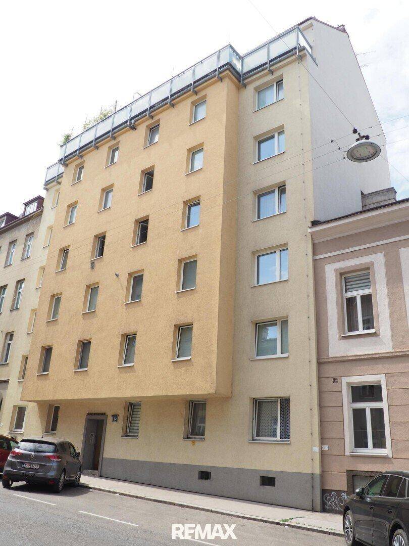 Mehrstöckiges Wohngebäude mit moderner Fassade und Balkonen an einer Stadtstraße.