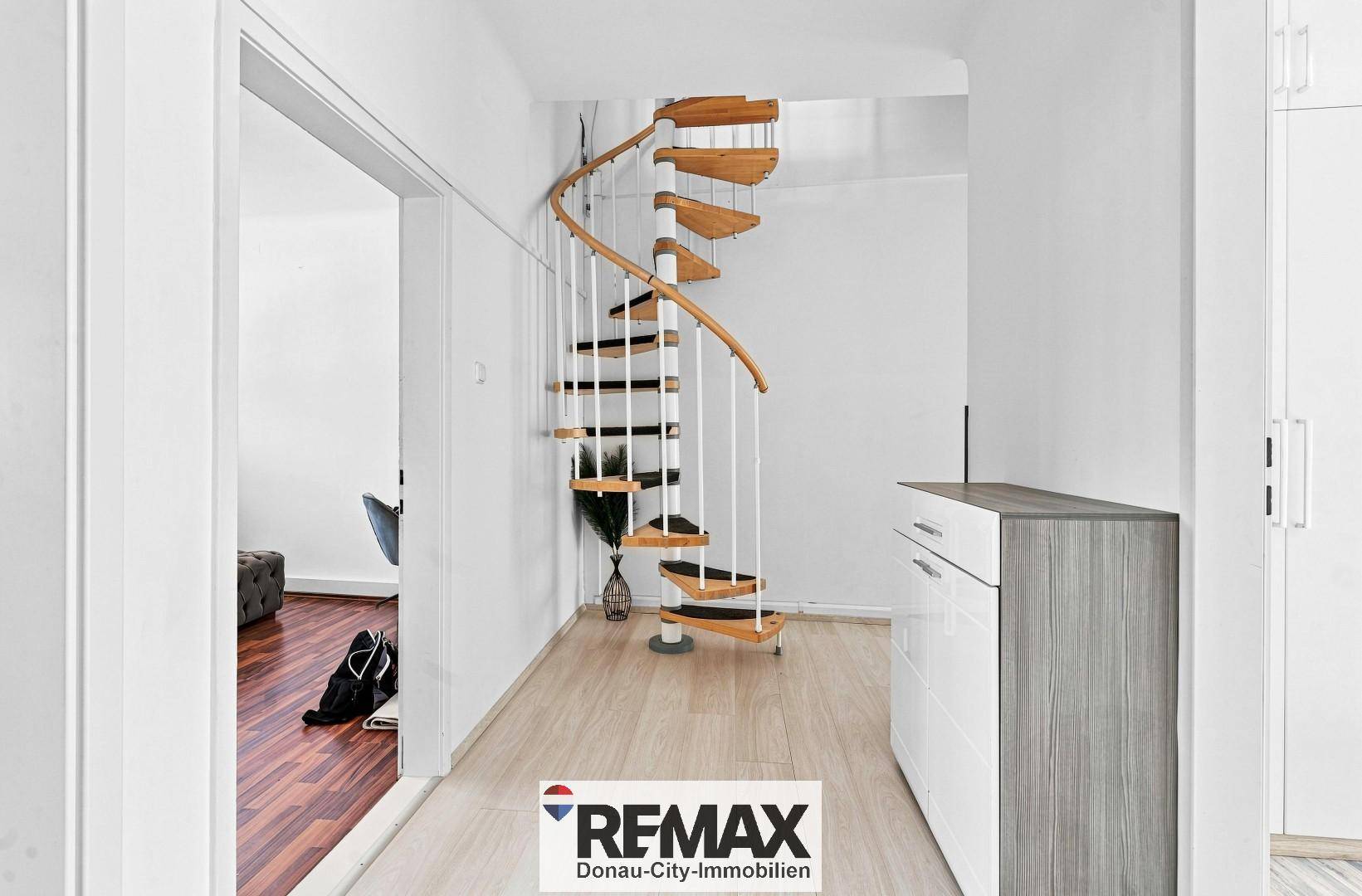 Heller Flur mit eleganter Holz-Wendeltreppe und modernem Sideboard.