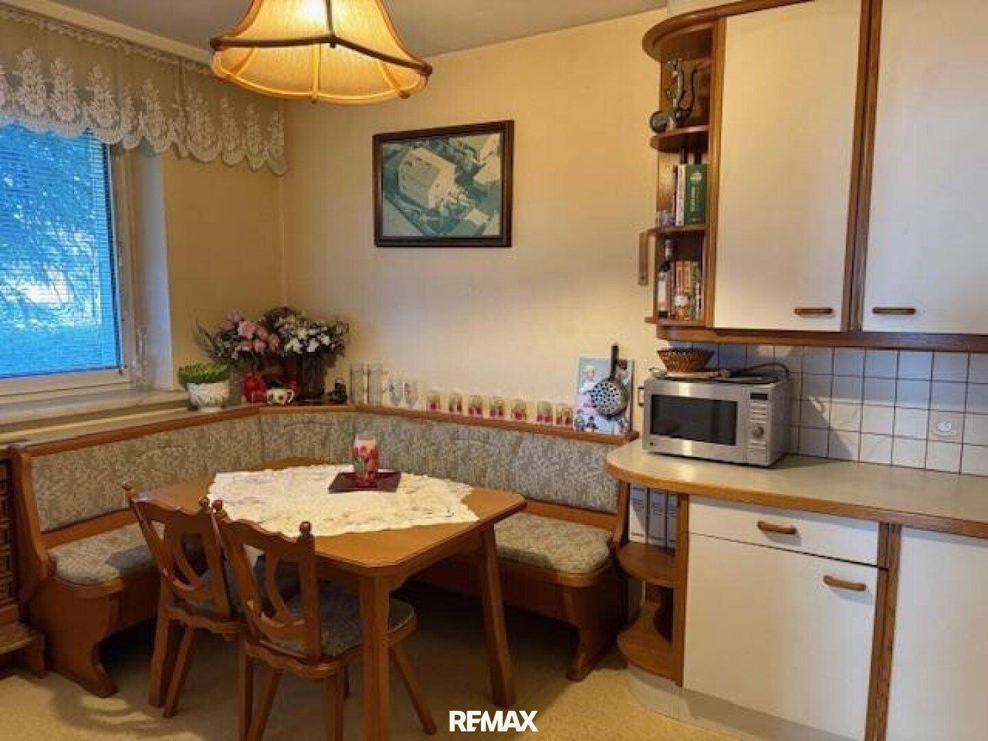 Essküche mit traditioneller Eckbank, Holztisch und integrierter Mikrowelle.