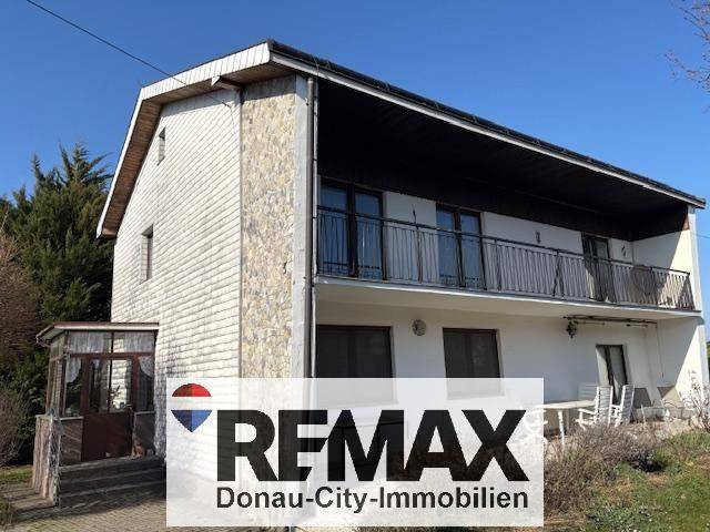 Ansicht des Hauses mit Balkonen und einer Mischung aus Putz- und Holzfassade.