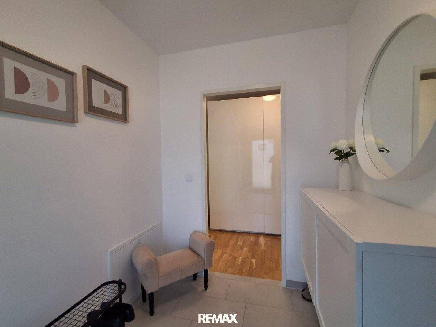 Heller Eingangsbereich mit Garderobe, Spiegel und praktischem Stauraum, einladend gestaltet.