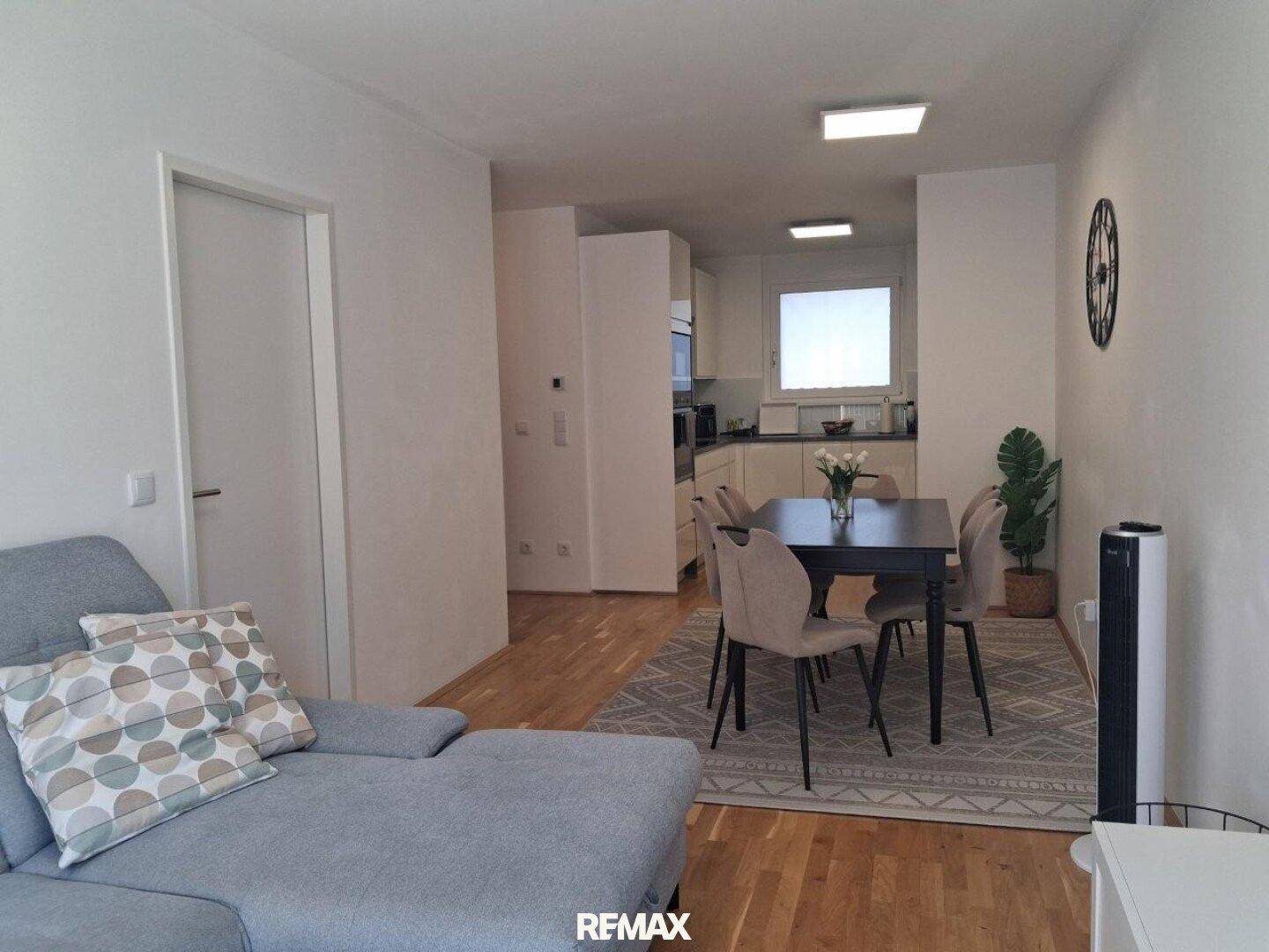 Offener Wohn-Essbereich mit gemütlichem Sofa, Esstisch und direktem Zugang zur Küche.