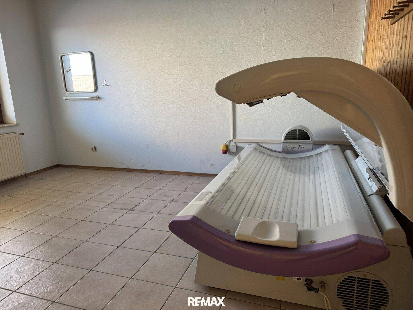 Raum mit Fliesenboden und einem Solarium, ideal für Entspannung und Wellness.