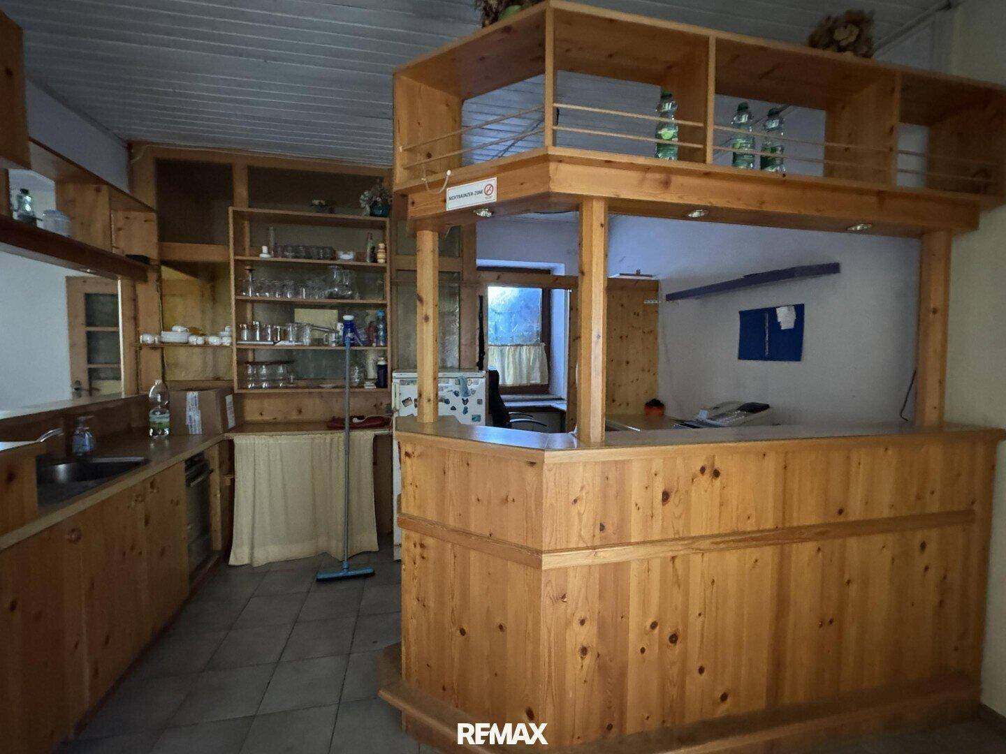 Rustikale Holzbar mit integrierter Spüle und Regalen für Gläser, ideal für Unterhaltung.