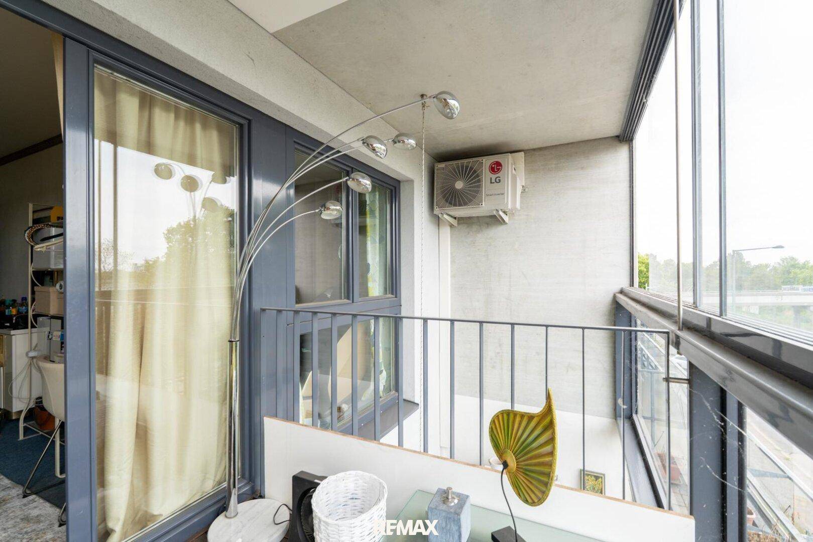 Verglaste Loggia mit Klimaanlage und Blick nach draußen, ideal für Entspannung.