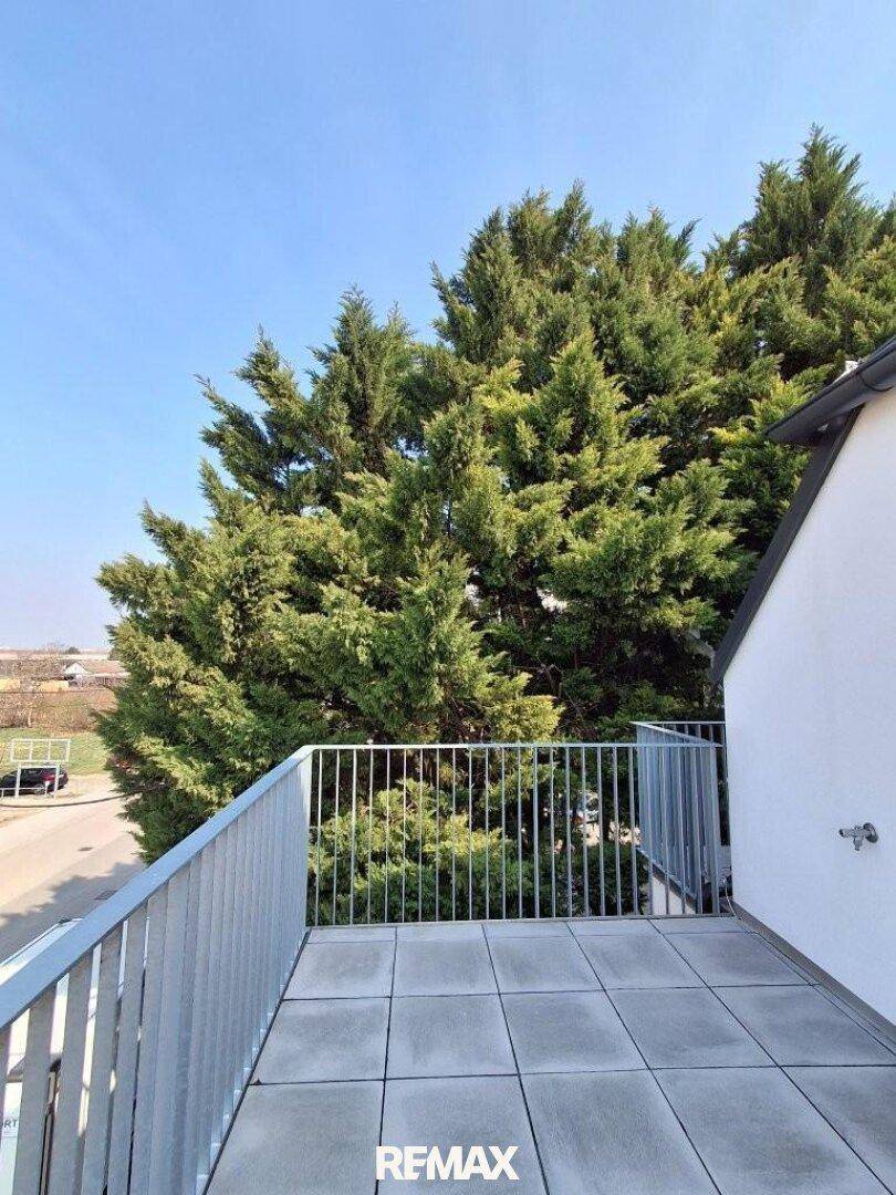 Balkon mit Fliesenboden und weitem Blick ins Grüne und die Umgebung.