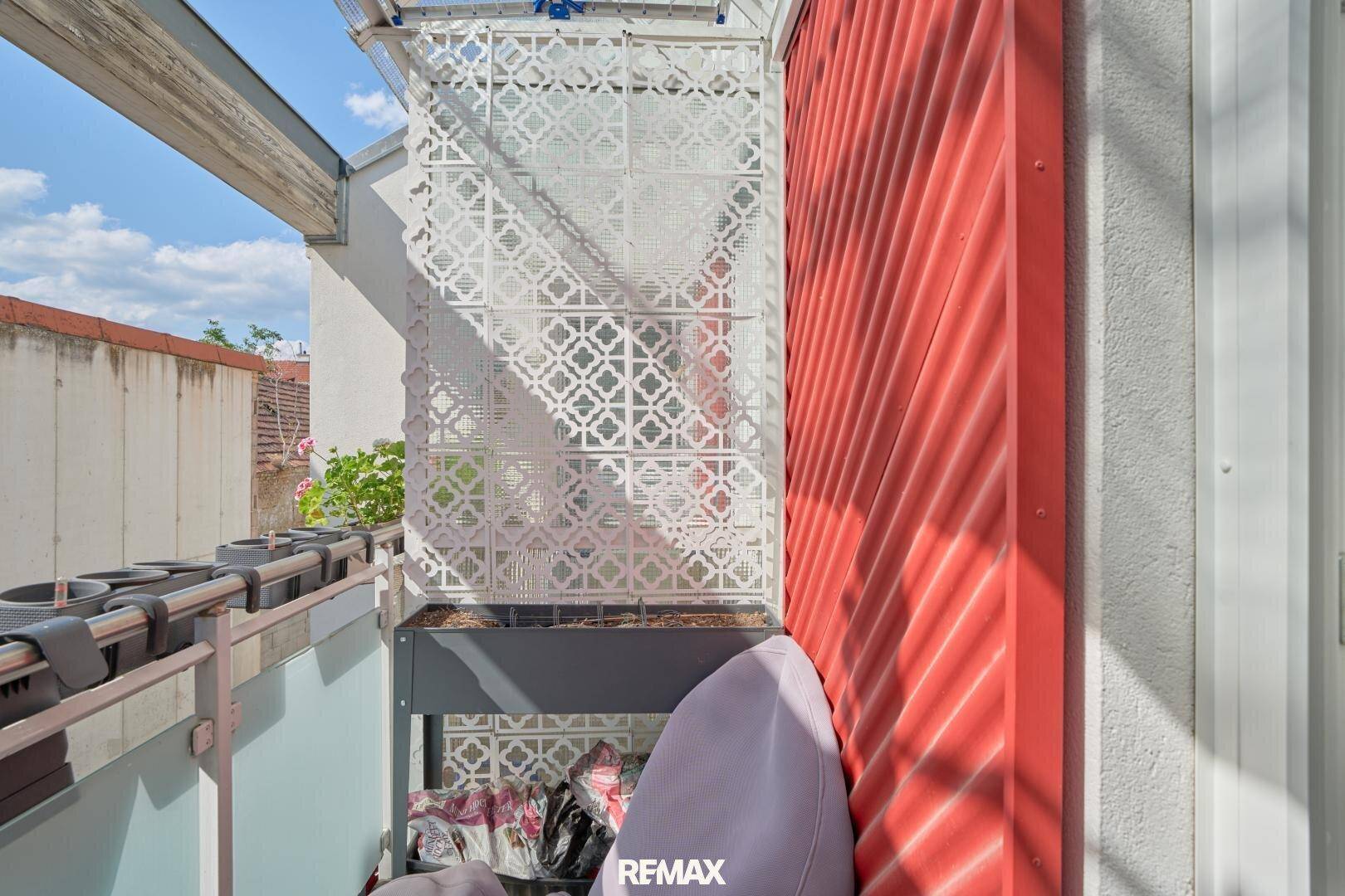 Kleiner Balkon mit dekorativem Gitter und Blick auf die Umgebung.