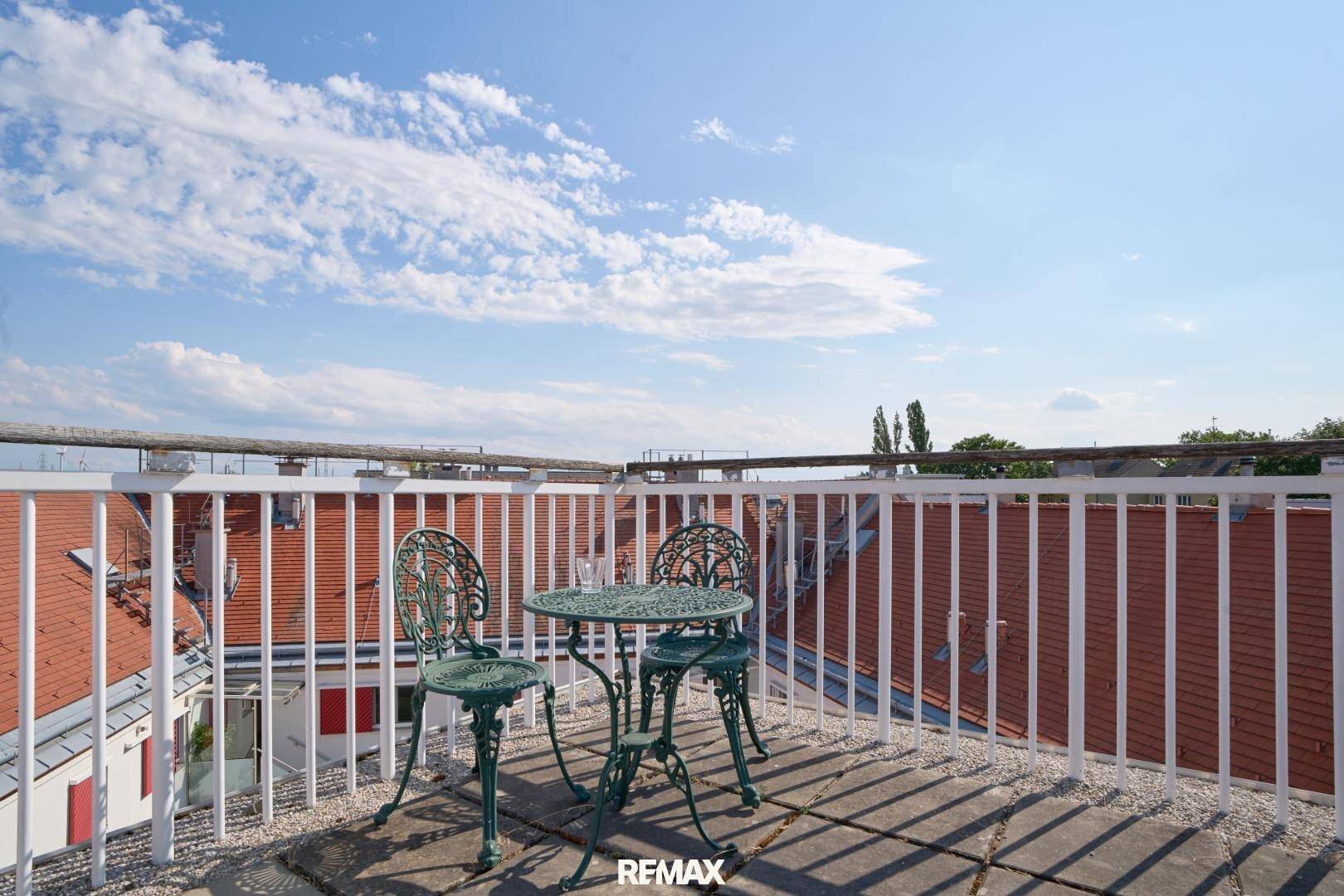 Dachterrasse mit schmiedeeisernen Möbeln und weitem Blick über die Dächer.