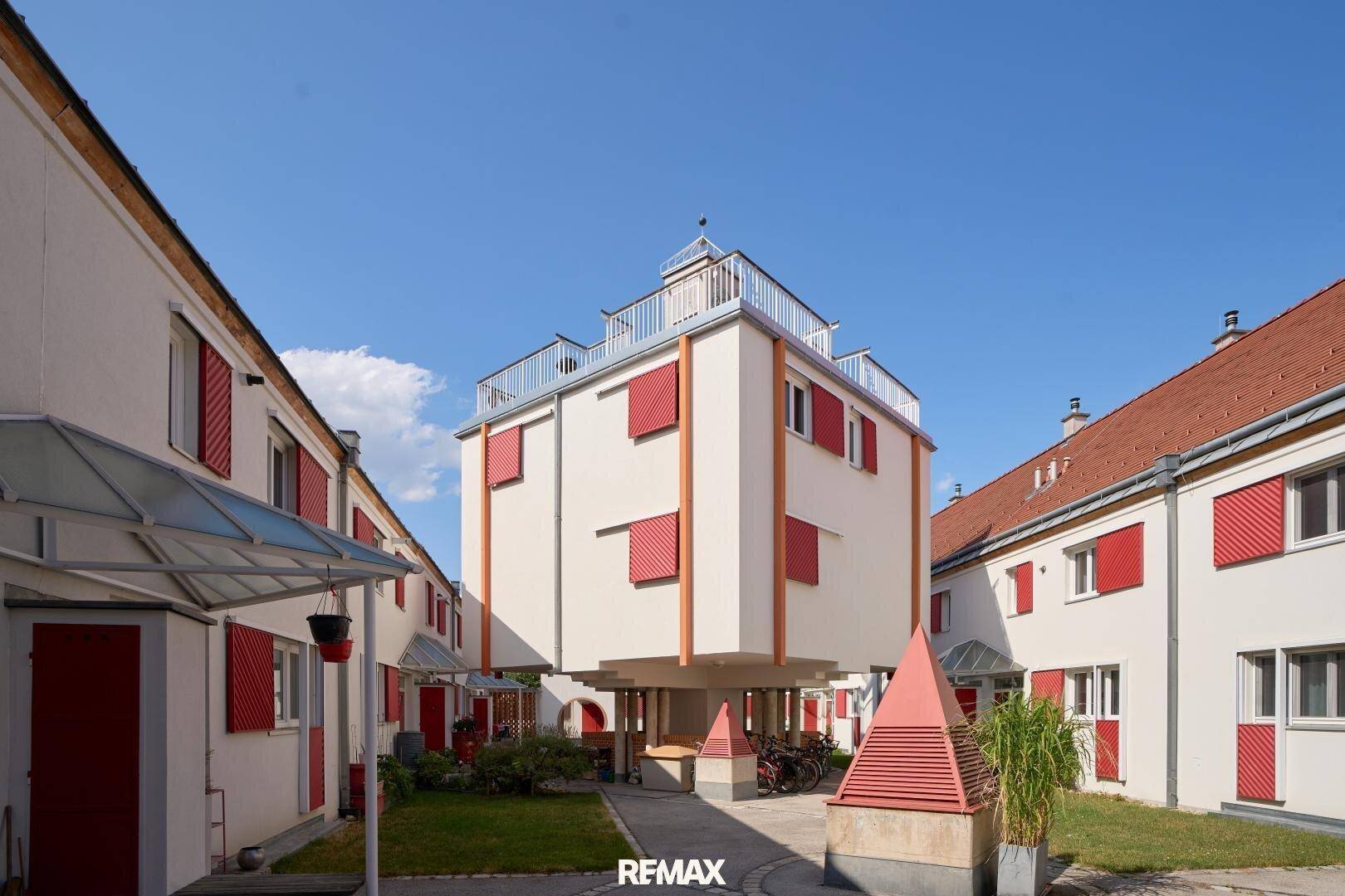 Moderne Wohnanlage mit ungewöhnlicher Architektur und roten Fensterläden.