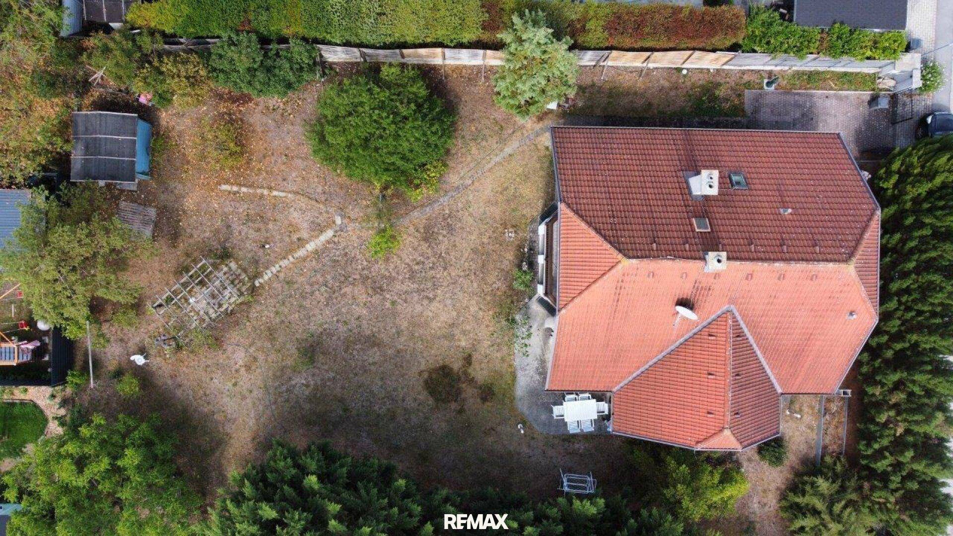 Luftaufnahme des Hauses mit großem Grundstück, Garten, Terrasse und umliegender Natur.