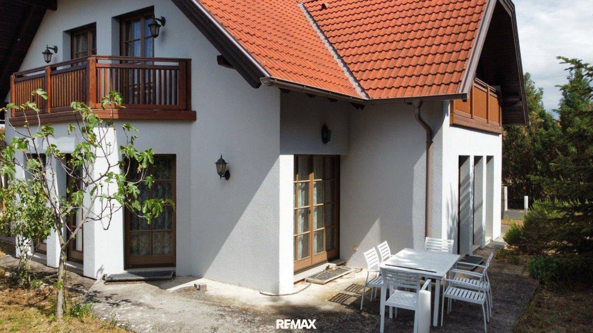 Gepflasterte Terrasse mit Gartenmöbeln neben dem Haus und direktem Zugang zum Garten.