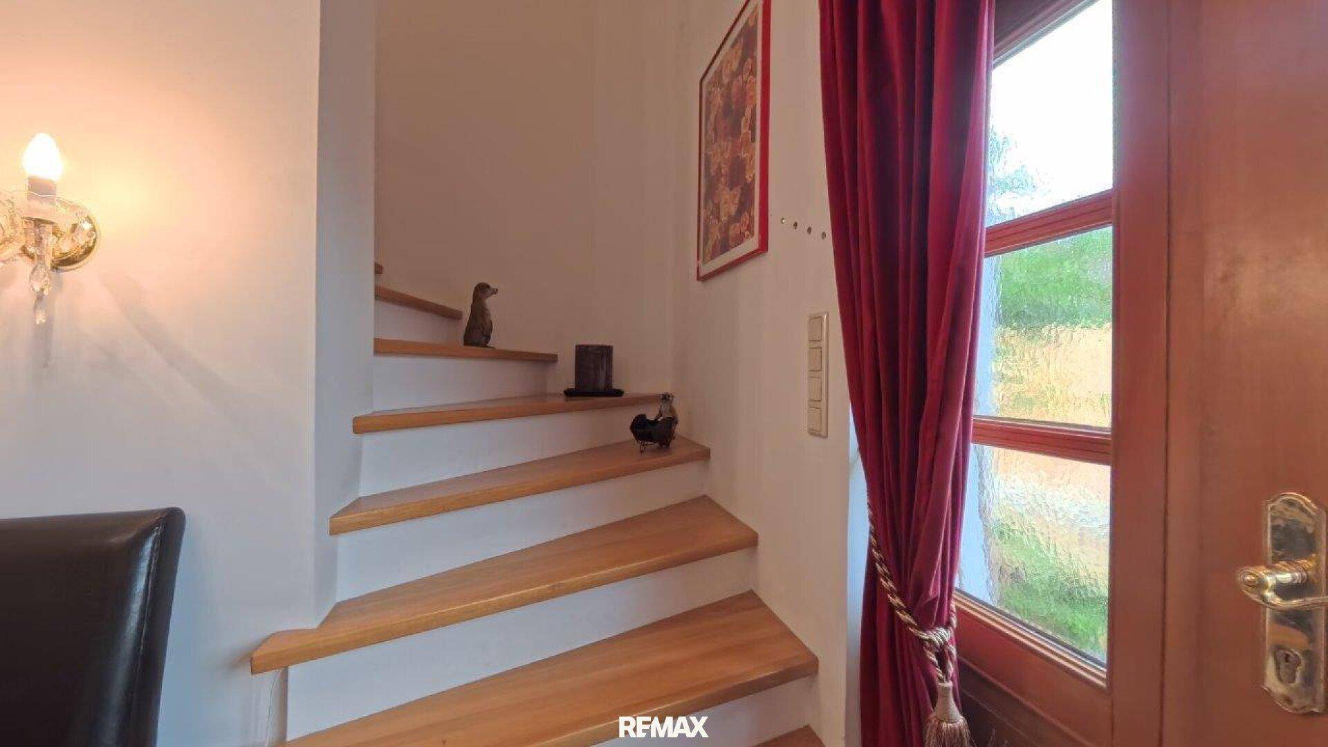 Holztreppe mit hellem Geländer und dekorativen Elementen.