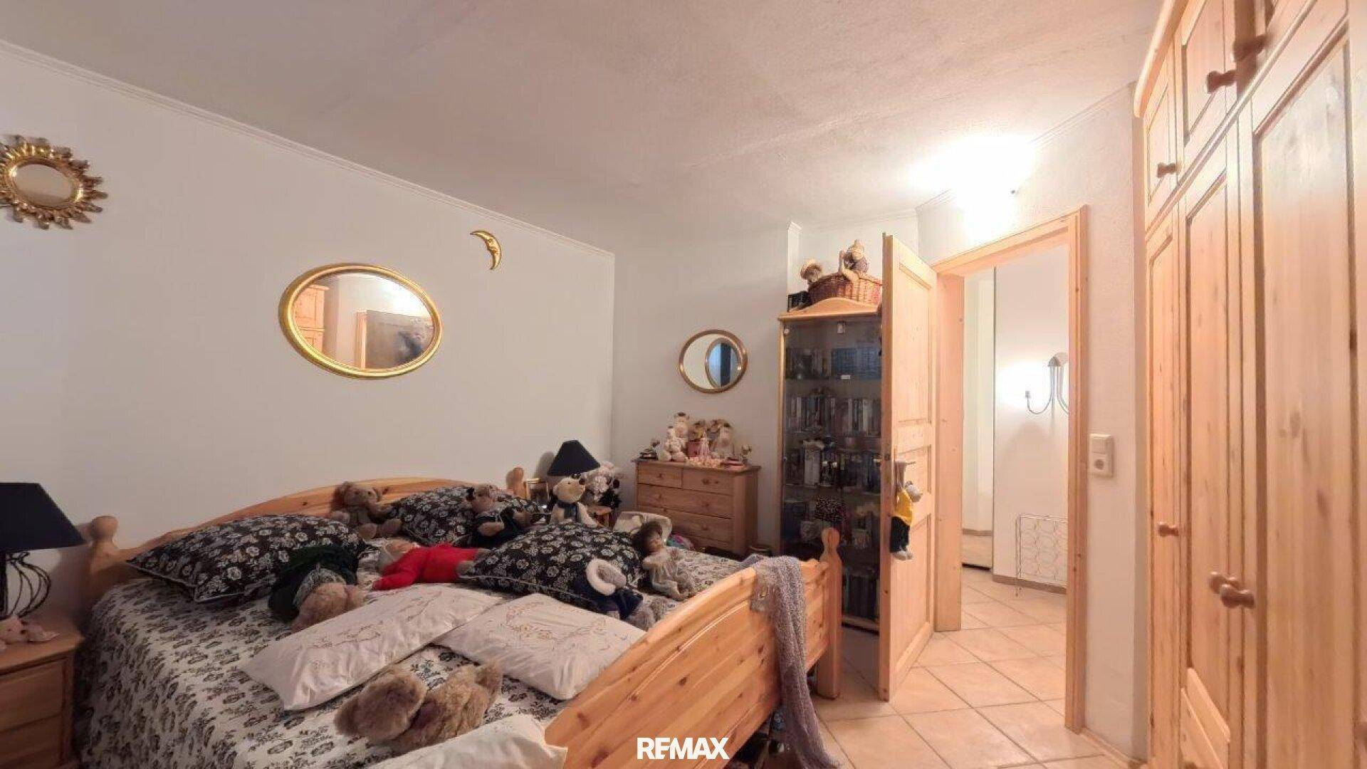 Gemütliches Schlafzimmer mit Holzbetten, vielen Kissen und Spiegeln.