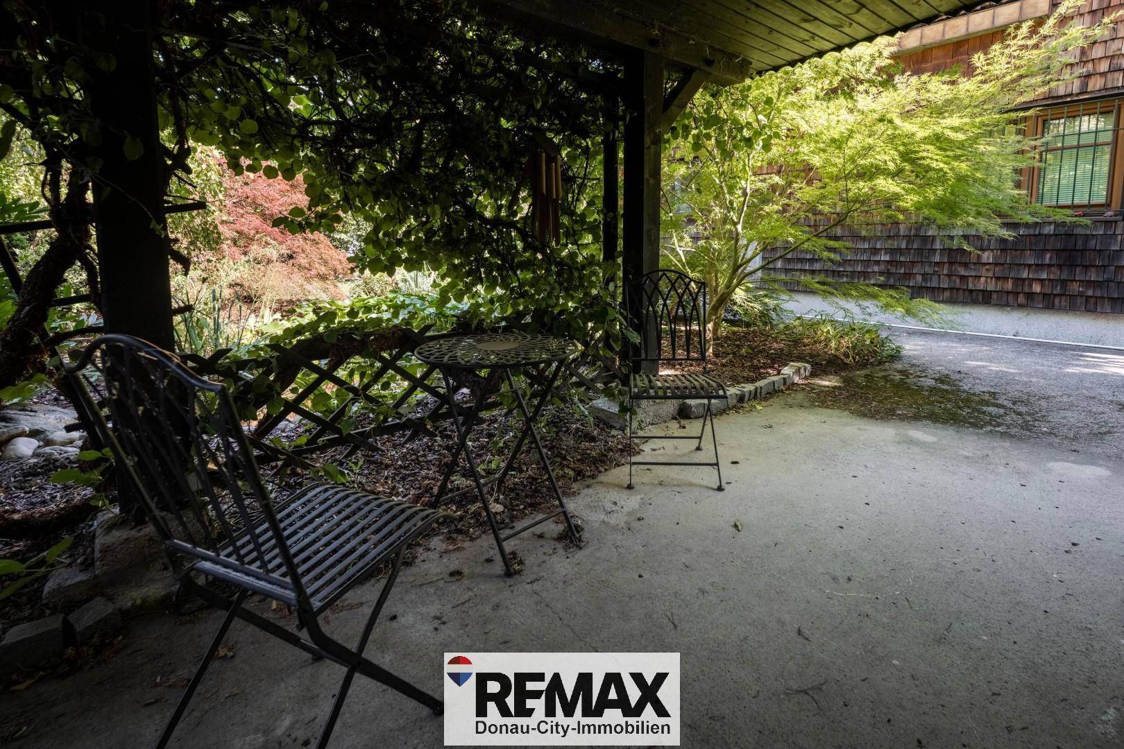 Überdachte Terrasse mit Metallmöbeln, ideal für entspannte Stunden im Freien.