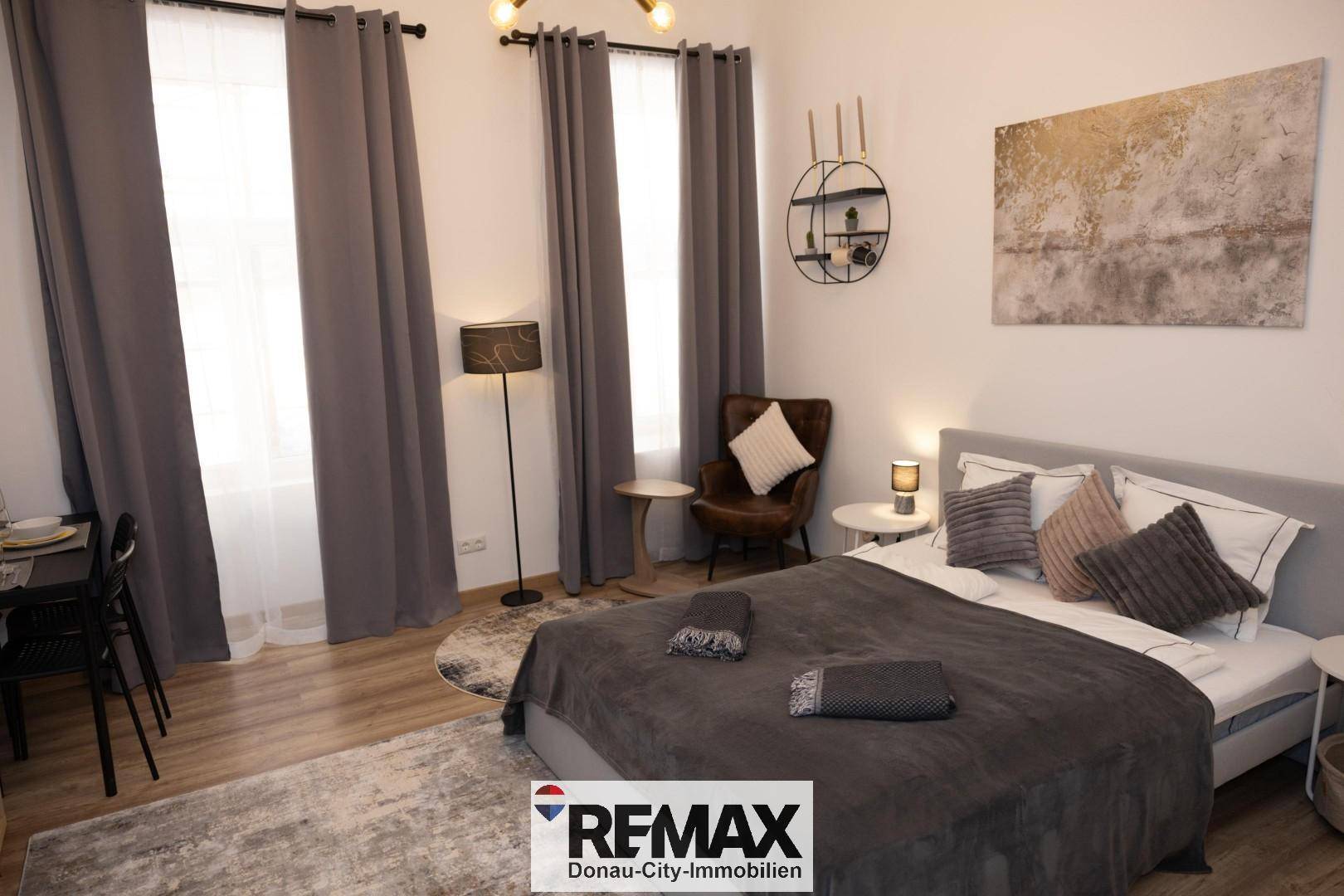Gemütliches Schlafzimmer mit Doppelbett, Sitzgelegenheit und kleinem Essbereich.